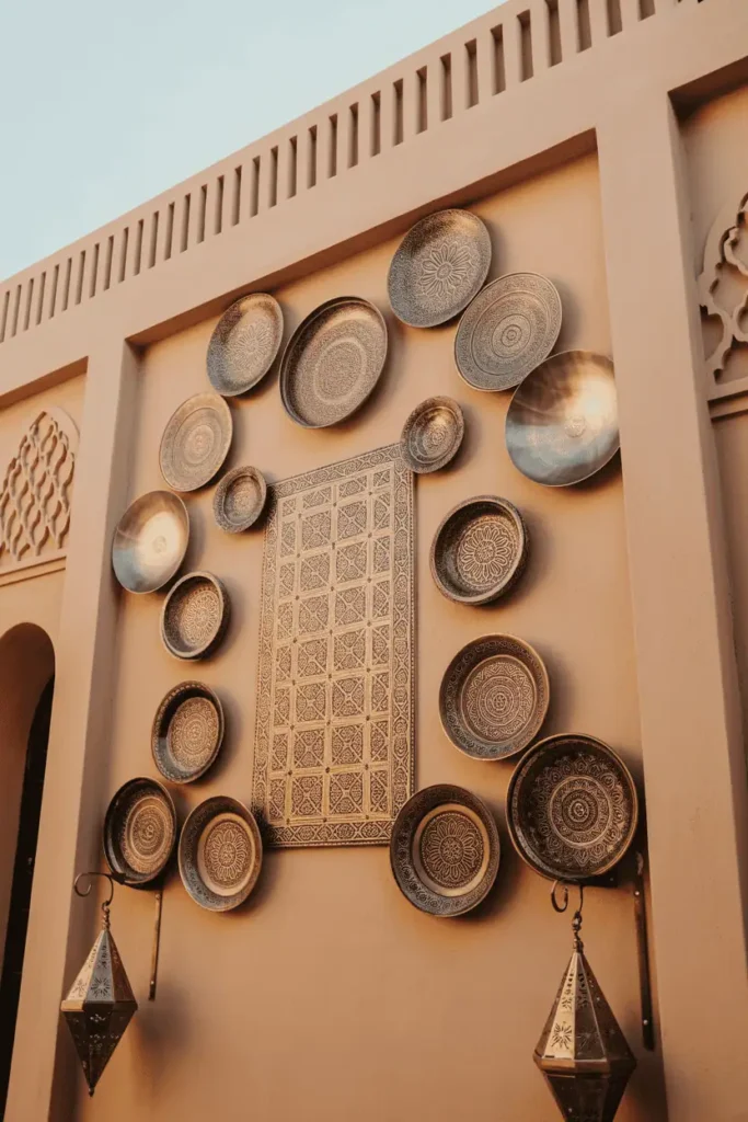 moroccan and middle eastern wall decor with intricate mosaic tiles, metal plates, and lanterns, geometric patterns in soft gold and terracotta tones, warm daylight photography, rustic-modern aesthetic with natural materials and handcrafted artistry